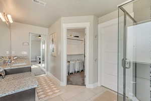 Bathroom featuring vanity, ceiling fan, and walk in shower