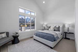 Bedroom featuring a mountain view, light carpet, and high vaulted ceiling