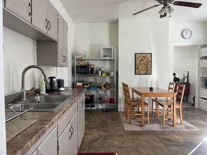 Kitchen with sink, white cabinets, and ceiling fan