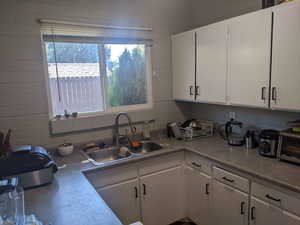 Kitchen featuring white cabinetry and sink