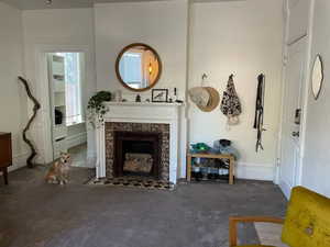 Living room with a premium fireplace and dark colored carpet