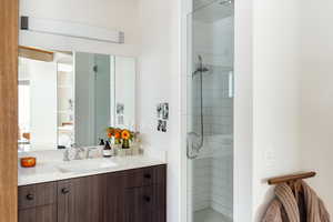 Bathroom featuring vanity and a shower with door