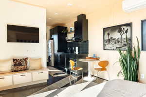 Living room featuring stacked washing maching and dryer, dark hardwood / wood-style flooring, and an AC wall unit