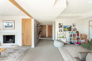 Carpeted living room featuring beam ceiling