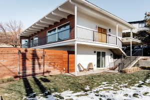 Snow covered property with a yard and a patio area