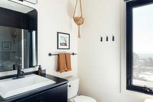 Bathroom with vanity, plenty of natural light, and a shower with shower door