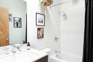 Full bathroom with vanity, toilet, and shower / bath combo with shower curtain