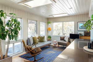 Sunroom / solarium featuring a skylight and wooden ceiling