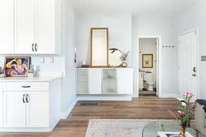 Interior space with dark wood-type flooring and white cabinets