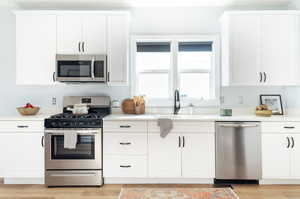 Kitchen featuring stainless steel appliances and white cabinets