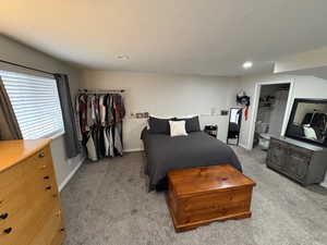 Bedroom with light colored carpet and a textured ceiling