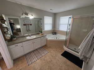 Bathroom with vanity and shower with separate bathtub