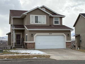 View of front of home with a garage and a mountain view