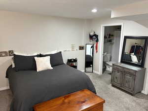 Carpeted bedroom featuring ensuite bathroom