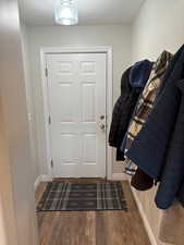 Doorway with dark hardwood / wood-style floors