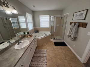 Bathroom featuring vanity and separate shower and tub