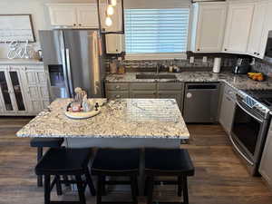 Kitchen featuring stainless steel appliances, a center island, sink, and a breakfast bar