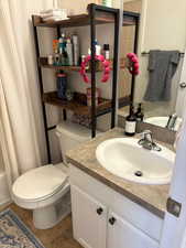 Full bathroom with vanity, shower / bath combo, and toilet