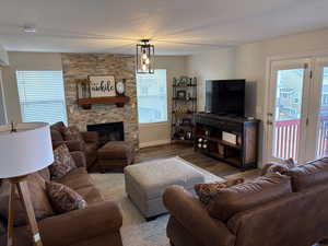 Living room with plenty of natural light, a fireplace, and hardwood / wood-style floors