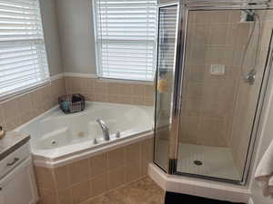 Bathroom with vanity, separate shower and tub, and a wealth of natural light