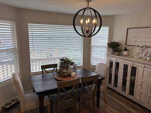 Dining space featuring dark hardwood / wood-style flooring and a notable chandelier