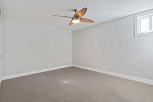 Empty room with ceiling fan and carpet flooring