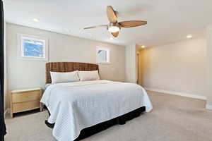 Carpeted bedroom featuring ceiling fan