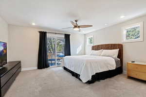 Carpeted bedroom featuring access to outside and ceiling fan