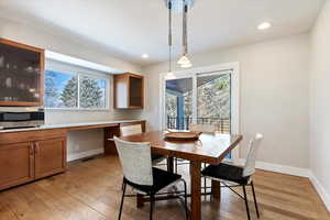 Dining area with built in desk, a healthy amount of sunlight, and light wood-type flooring