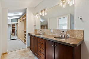 Bathroom featuring vanity and decorative backsplash