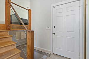 Entryway with wooden walls and light tile patterned floors