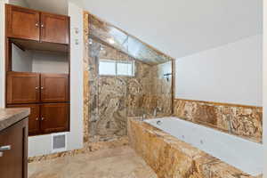 Bathroom featuring vanity, separate shower and tub, and vaulted ceiling