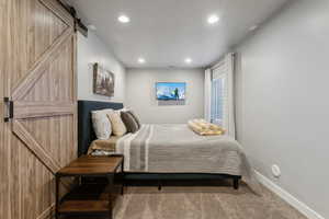 Carpeted bedroom with a barn door