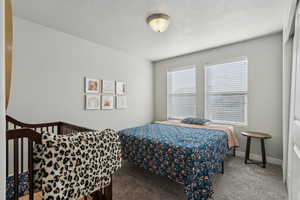 Carpeted bedroom with a textured ceiling