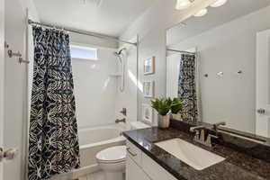 Full bathroom with vanity, toilet, and shower / tub combo with curtain