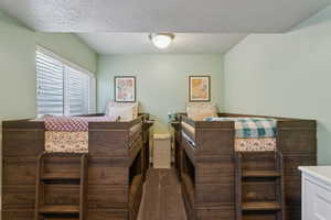 Bedroom featuring dark carpet and a textured ceiling