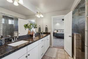 Bathroom with vanity, tiled shower, tile patterned floors, and ceiling fan