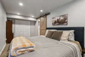 Bedroom with a closet, carpet floors, and a barn door