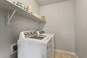 Laundry room with separate washer and dryer and light tile patterned floors