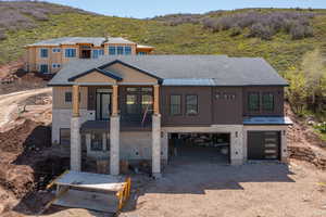 View of front of property featuring a garage, driveway, and a mountain view