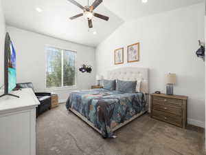 Bedroom featuring vaulted ceiling, ceiling fan, and carpet flooring