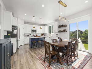 Dining space with sink, light hardwood / wood-style flooring, and a healthy amount of sunlight