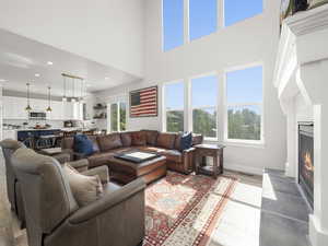 Living room featuring a high ceiling, a high end fireplace, and light hardwood / wood-style flooring