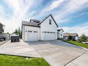 View of home's exterior with a garage and a lawn