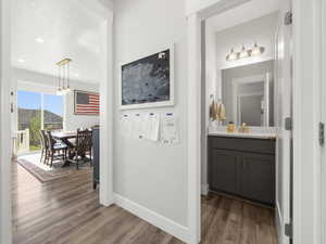 Corridor with hardwood / wood-style flooring, sink, and a chandelier