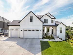 View of front of house with a garage and a front lawn