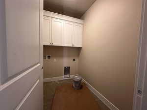 Laundry room with hookup for an electric dryer, baseboards, washer hookup, and cabinet space