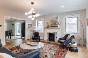 Living room featuring hardwood / wood-style flooring, a fireplace, and a chandelier