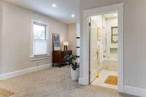 Hallway featuring light carpet