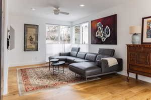 Living room with wood-type flooring and ceiling fan